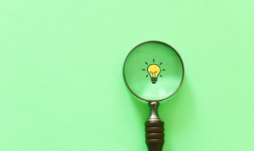 Illustration of a lightbulb under a magnifying glass
